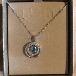 diamond accents surrounding a blue topaz stone.